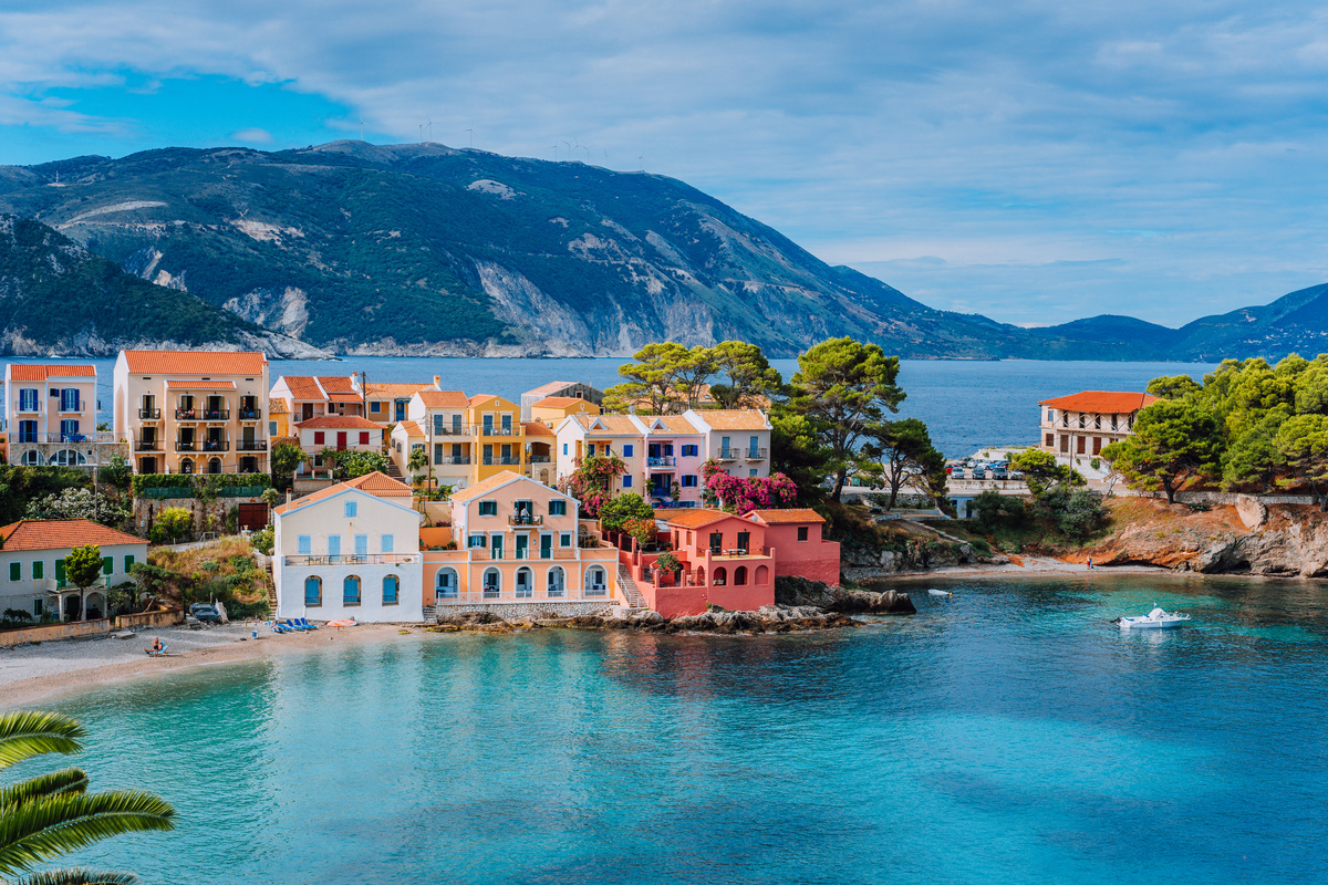 Beautiful panoramic view of Assos village with vivid colorful houses near blue turquoise colored and transparent bay lagoon. Kefalonia, Greece